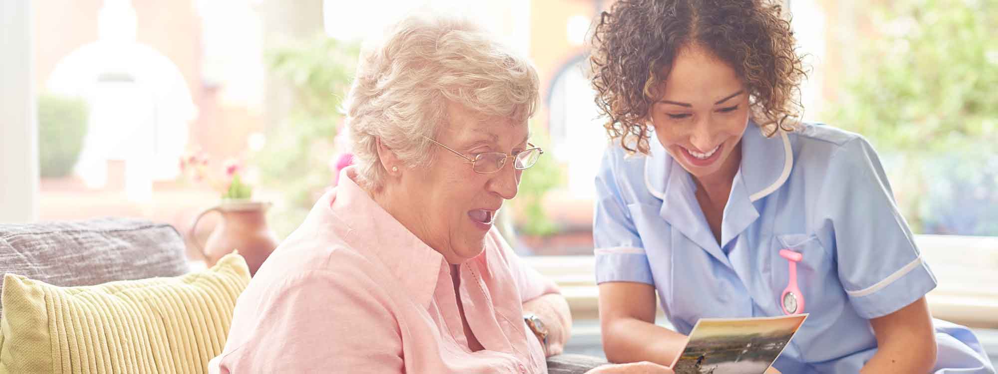 A lady and her caregiver reviewing the cost of assisted living vs in home care