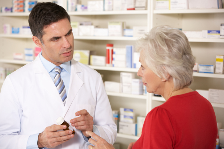 A pharmacist discussing atorvastatin benefits with a lady
