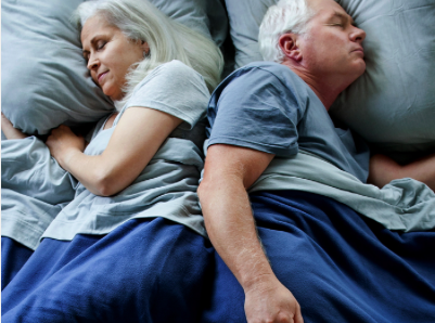 A couple sleeping in bed. They don't seem to have trouble with sleep deprivation in elderly people.